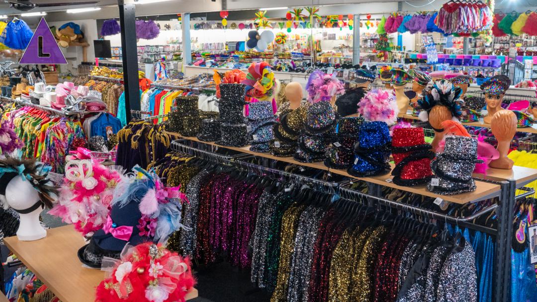 Foto van het interieur van de carnavalswinkel van Plantinga Carnaval met glitterjasjes, hoedjes met veren, glitterhoedjes en nog veel meer